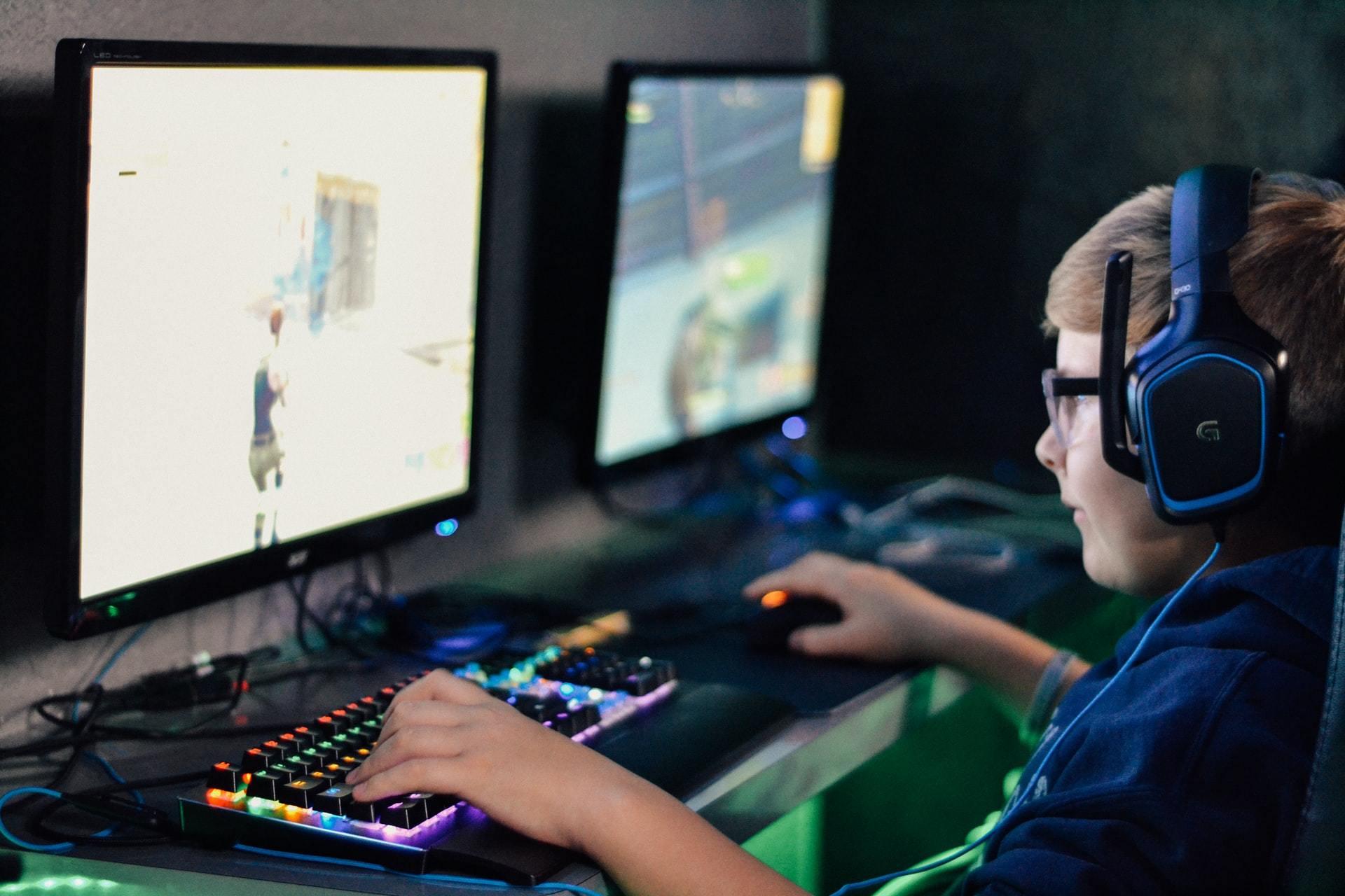 A gamer is playing a video game, wearing headset